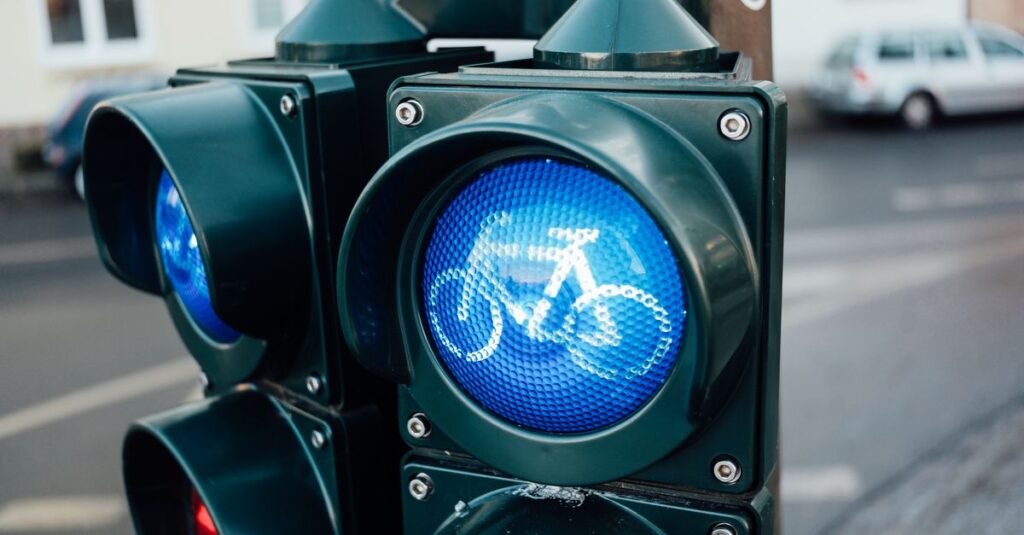 信号を無視して交差点に進入する自転車のイラスト。赤信号を無視する危険性を強調した図。