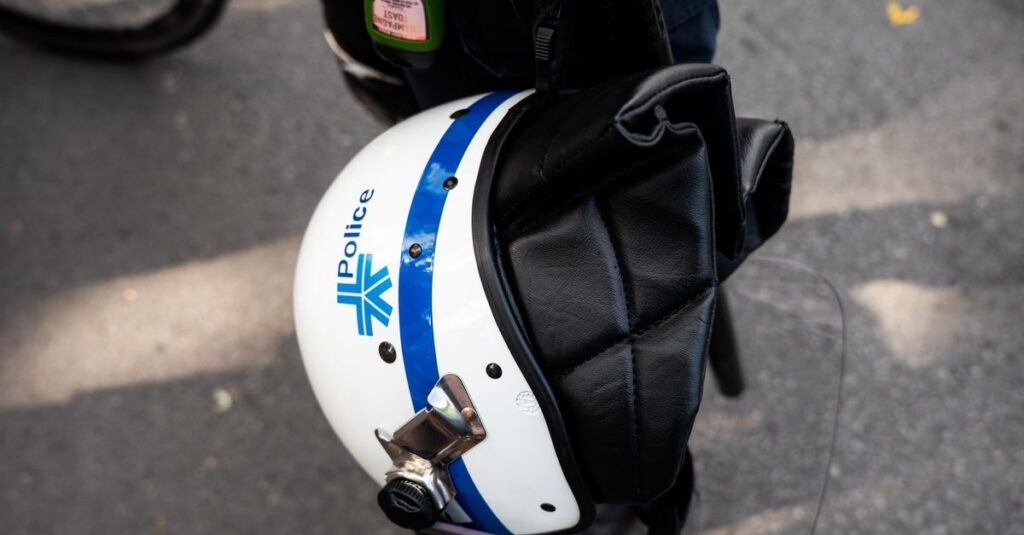 警察官が通勤中の自転車違反を指導している場面。信号無視やスマホ操作の取り締まり実態をイメージした説明画像。