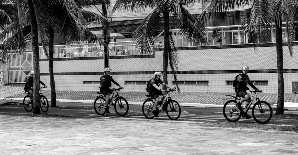 警察官が通勤中の自転車違反を指導している場面。信号無視やスマホ操作の取り締まり実態をイメージした説明画像。