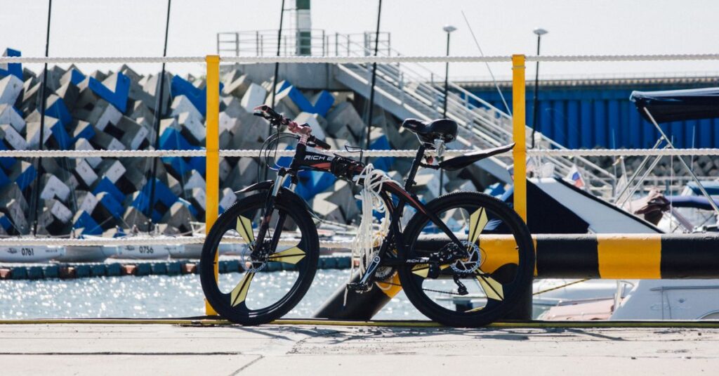 自転車の安全装備グッズを並べたイラスト。ヘルメット・ライト・反射材・スマホホルダーなどを説明。